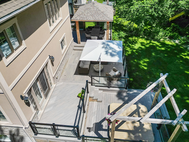 Aerial view of composite deck in backyard, outdoor living space with a pergola, pavilion, and fire pit.